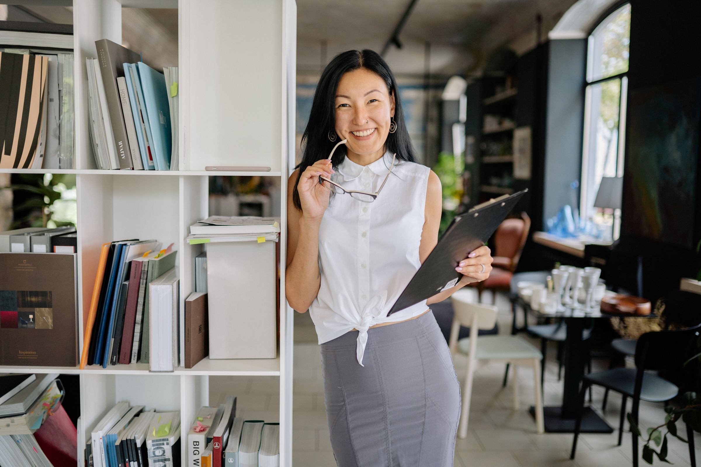 Smiling front-desk officer holding a clipboard.