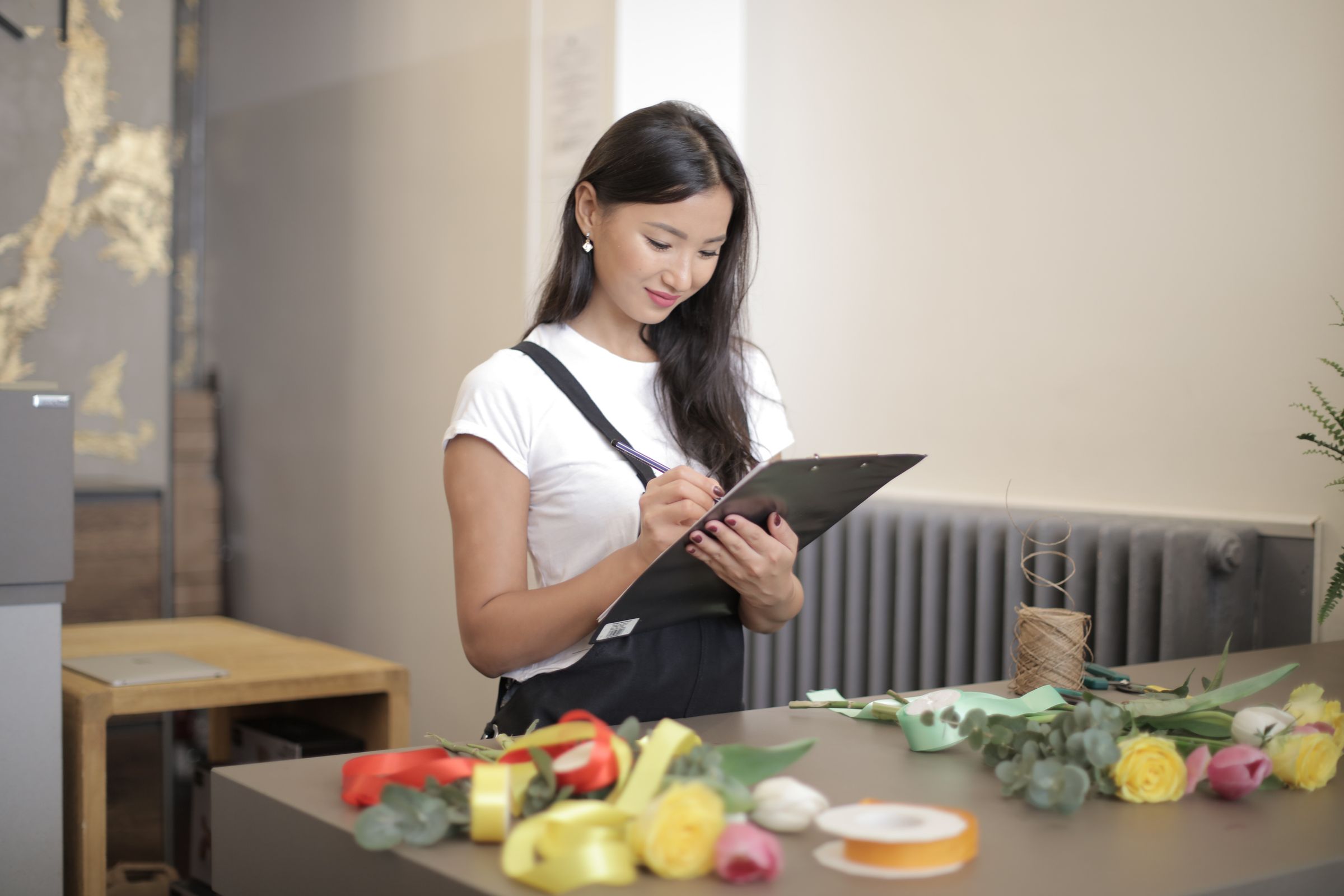 Shop owner checking online orders on a tablet.
